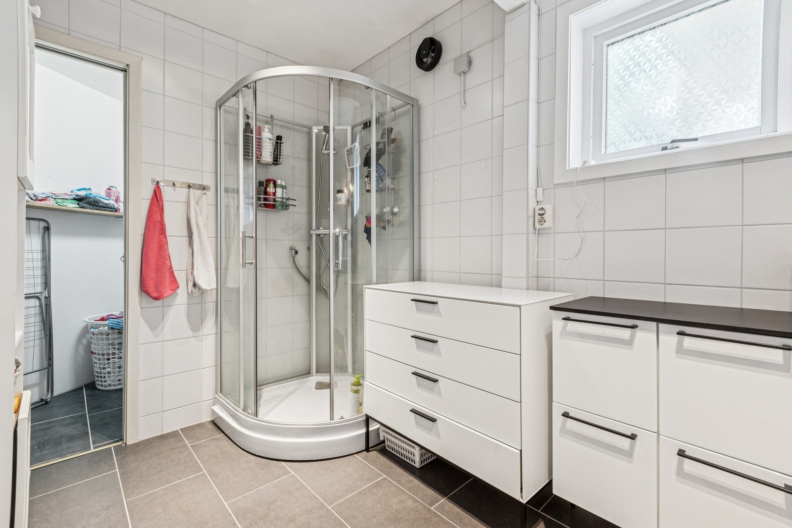 Badet i 1.etasje har flislagt gulv med varmekabler og fliser på vegg. Galleribilde