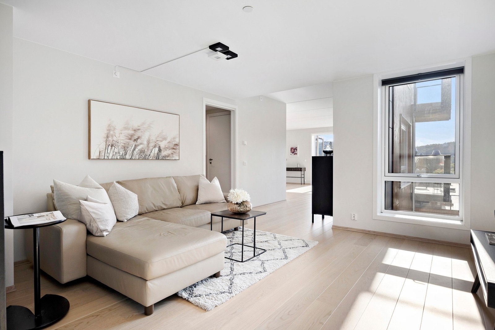 Inn fra entreen møtes man av hall/stue som knytter boligens ytterligere rom sammen Galleribilde