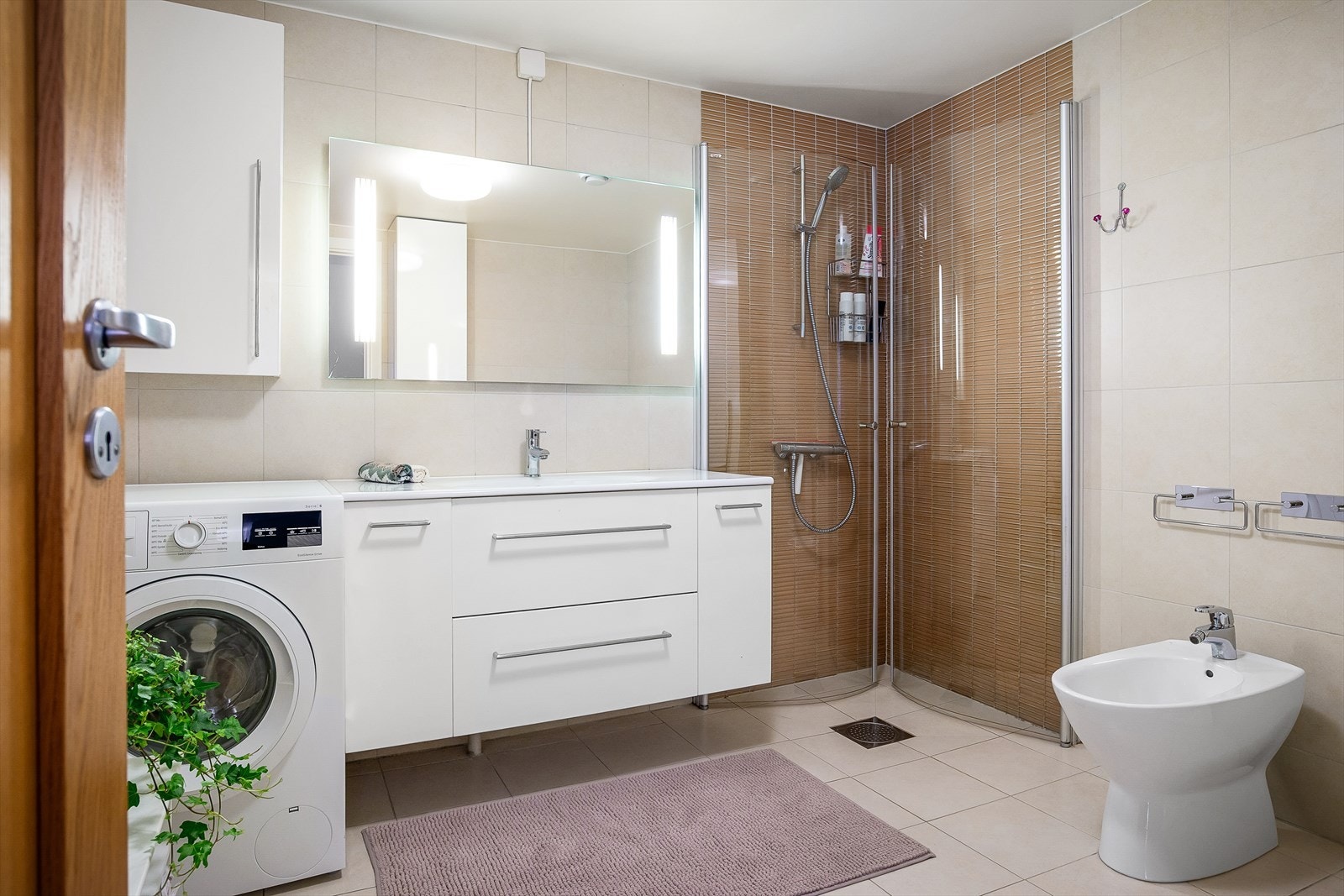 Romslig baderom fra byggeår i 2009 med vegghengt servantskap med ovenpåliggende servant med ettgreps armatur fra Harfa. Galleribilde