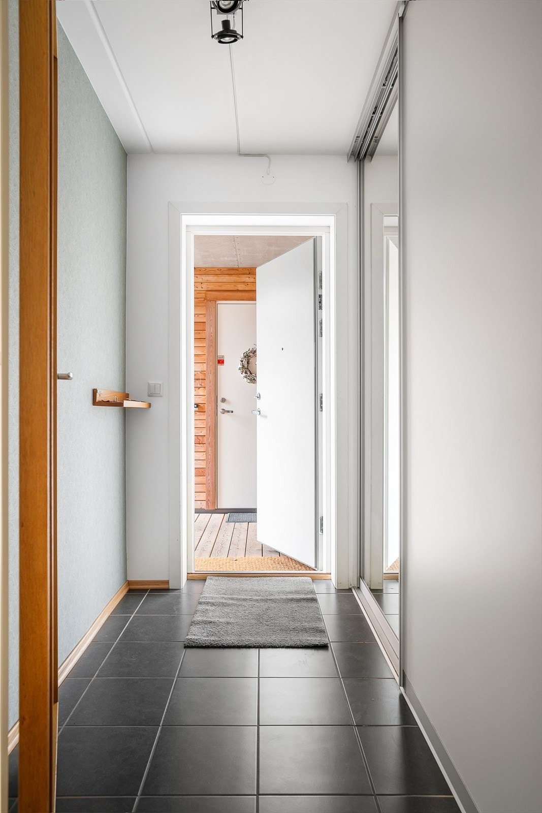 Lys og praktisk entré med skyvedørsgarderobe langs den ene veggen med speildør. Galleribilde