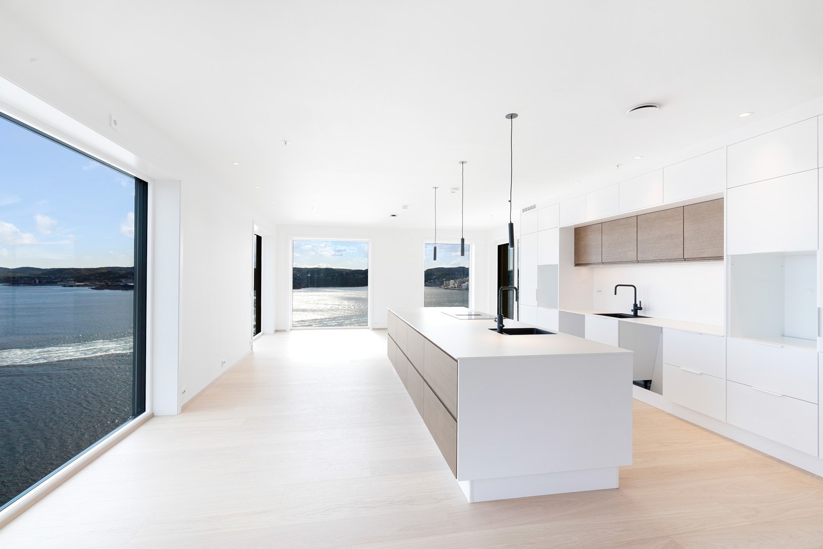 Det betydelig oppgraderte kjøkkenet fra Strai er stilrent, og naturlig plassert i rommet. Kjøkkenet har rikelig med oppbevaringsplass i under og overskap samt kjøkkenøy. Galleribilde