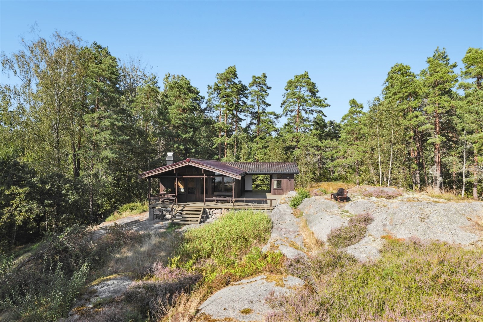 Rundt hytta er den fin vegetasjon, med svaberg opp i dagen. Det ligger to tomter bak/nord for hytta som også skal selges. Galleribilde