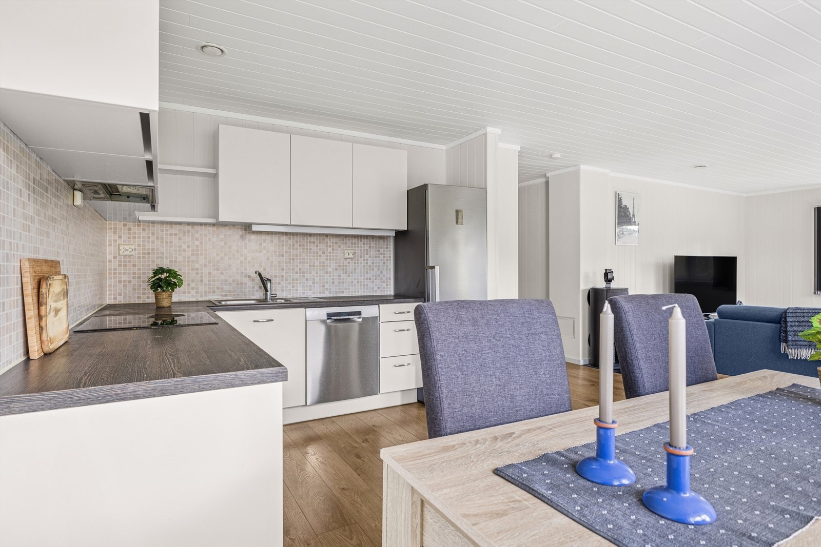 Kjøkkenet har innredning med glatte fronter, laminert benkeplate og fliser over benk. Galleribilde