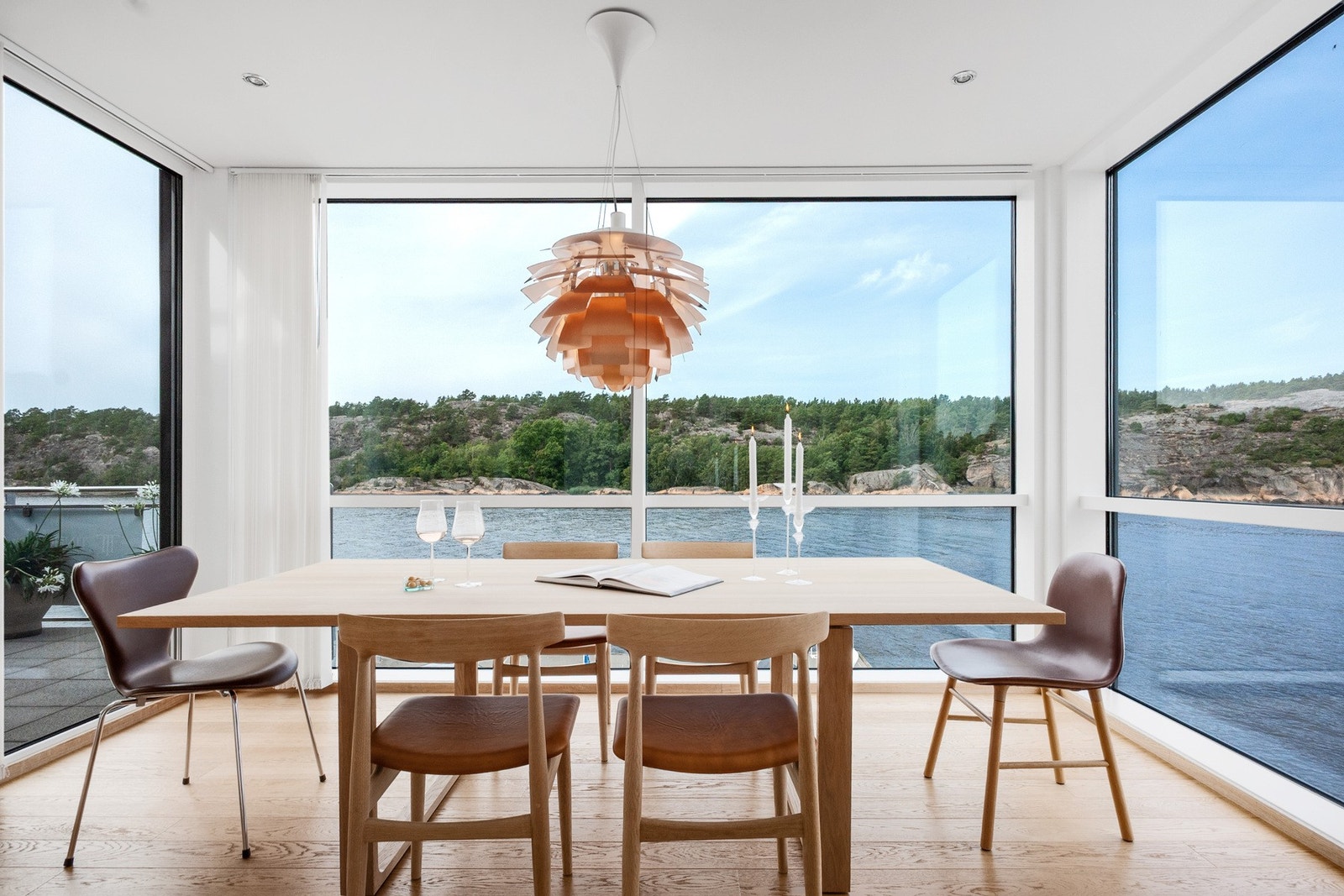 Store vindusflater slipper inn mye dagslys og gir en lys og behagelig atmosfære rundt bordet Galleribilde