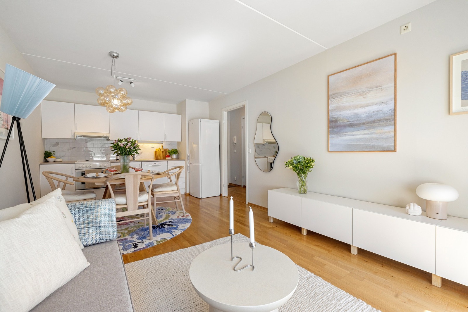 Leiligheten har en sosial planløsning med åpen stue og kjøkkenløsning vendt mot store vindusoverflater og balkong som skaper en innbydende atmosfære. Galleribilde