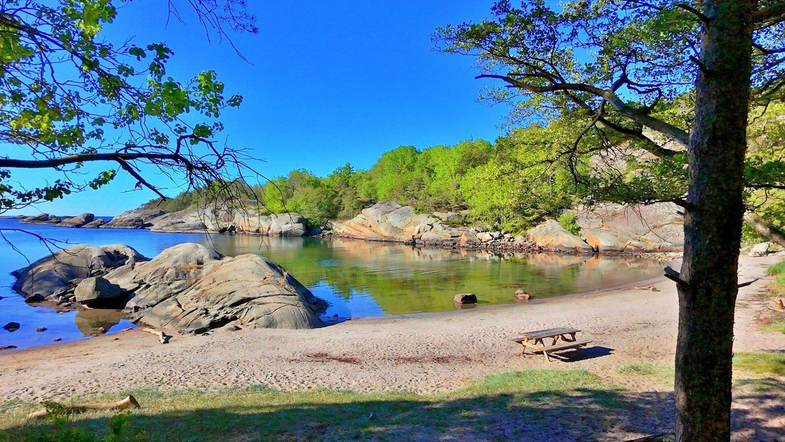 Skjermet og idyllisk - en av flere små bukter i området rundt Tallakshavn hvor du kan nyte fredelige dager ved vannet, omgitt av blankskurte svaberg og glitrende sjø. Galleribilde