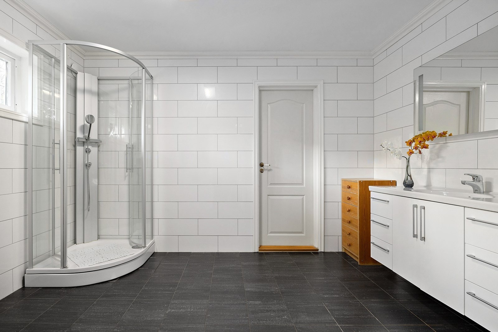 Badet inneholder vaskeservant, dusjkabinett og veggmontert toalett. Galleribilde