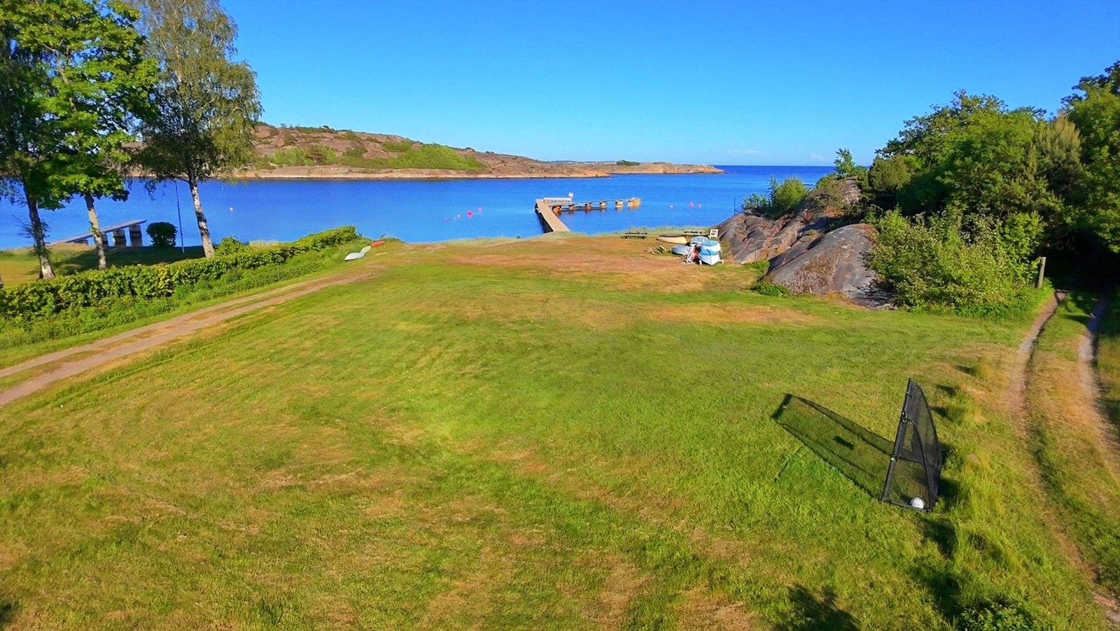 Fellesområdet har stor gresslette perfekt for lek, piknik og uformelle fotballkamper. Her kan både store og små trives, med sjøen og bryggen bare noen meter unna. Galleribilde