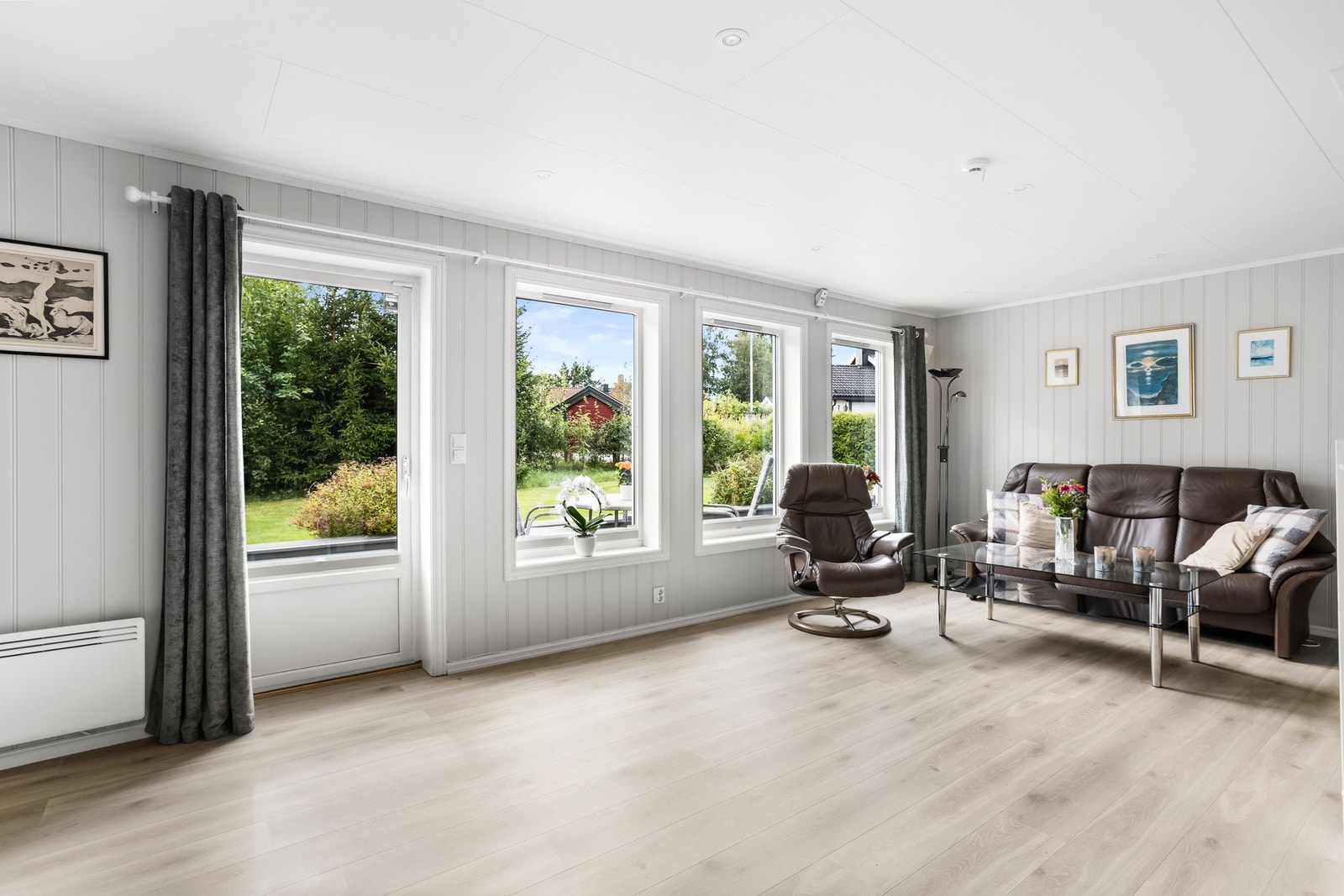 På gulvet er det lagt nyere laminat, mens veggene har panel i lysegrått. Galleribilde