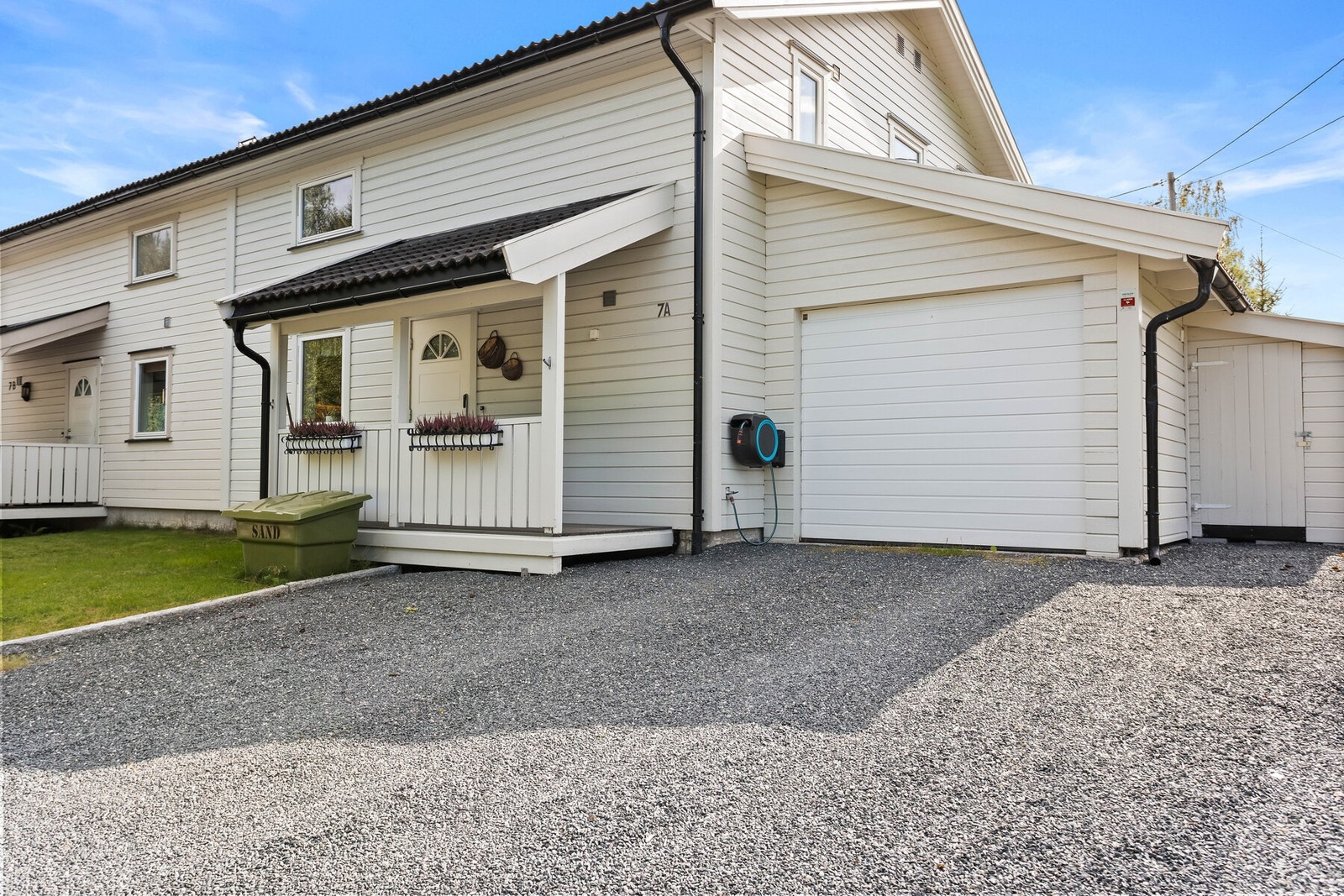 Boligen har en inntilliggende garasje med elbillader og utvendig bod med ekstra lagringsplass. Galleribilde
