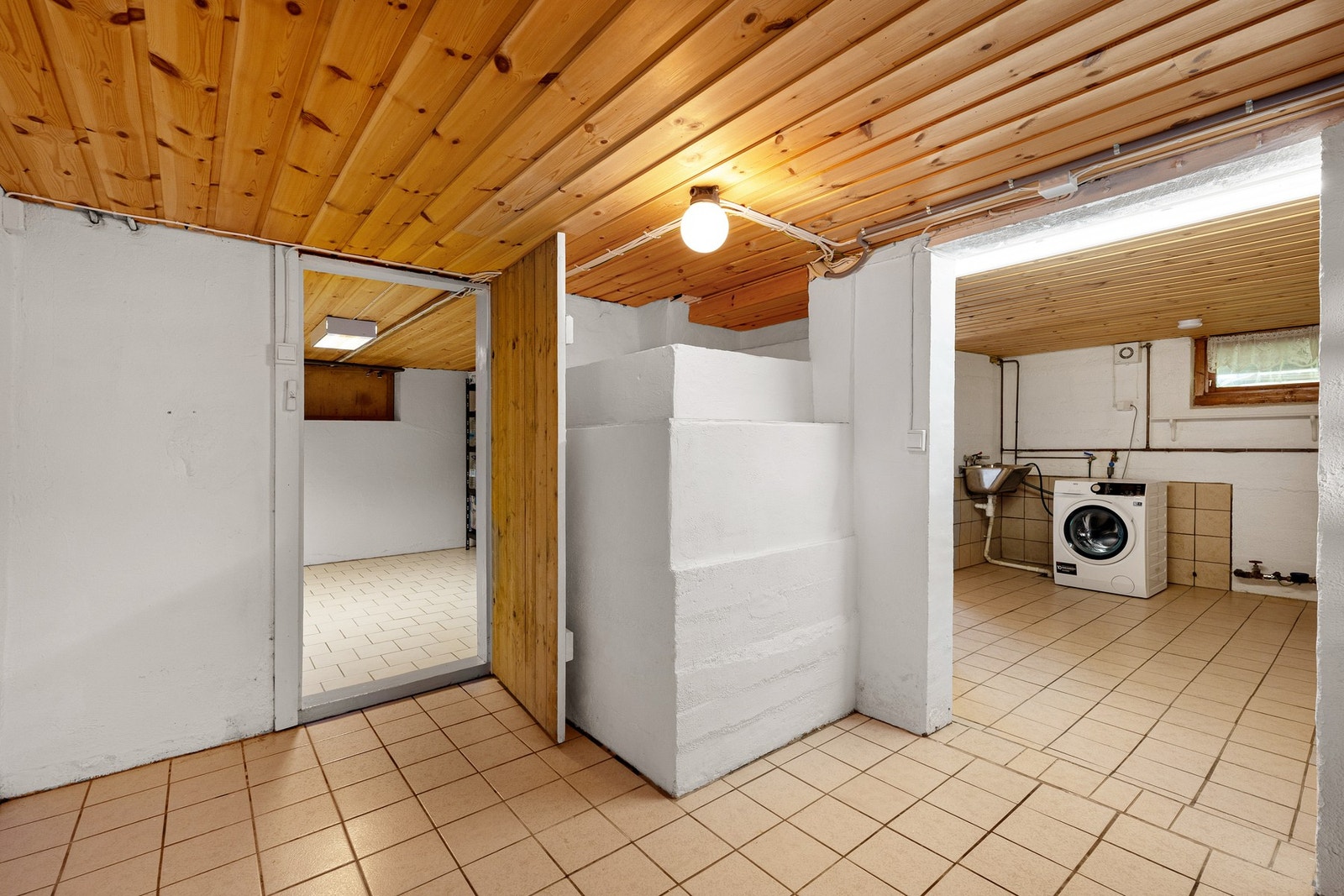 Det er montert vedovn, uttak for vaskemaskin og utslagsvask på vaskerommet i kjelleren. Galleribilde