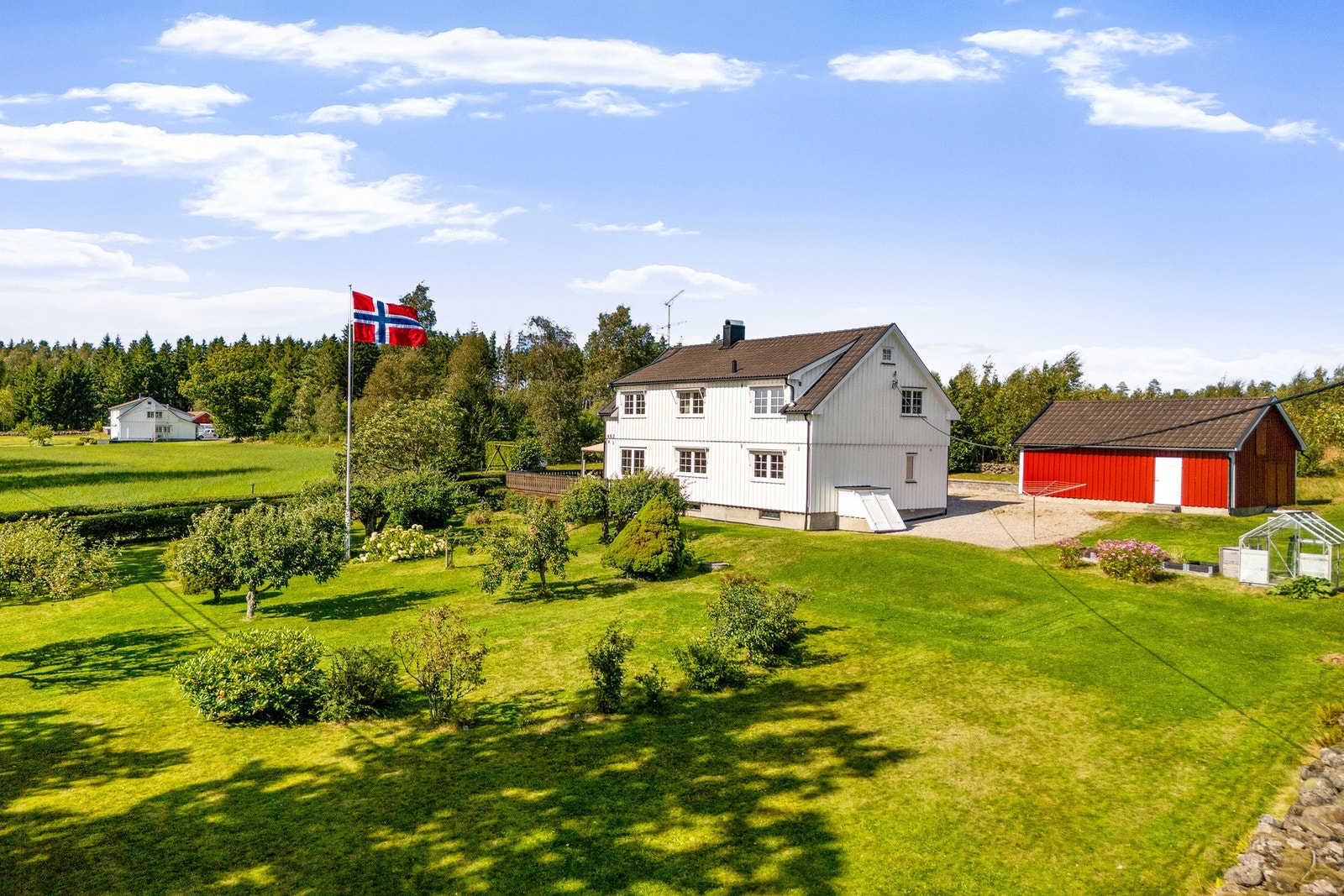 Landlig idyll på over 2 mål - Solrik tomt med blant annet eple-, pære-, plomme- og morelltrær, rips-, solbær- og stikkelsbærbusker, blomster, busker, drivhus og romslig gårdsplass. Galleribilde