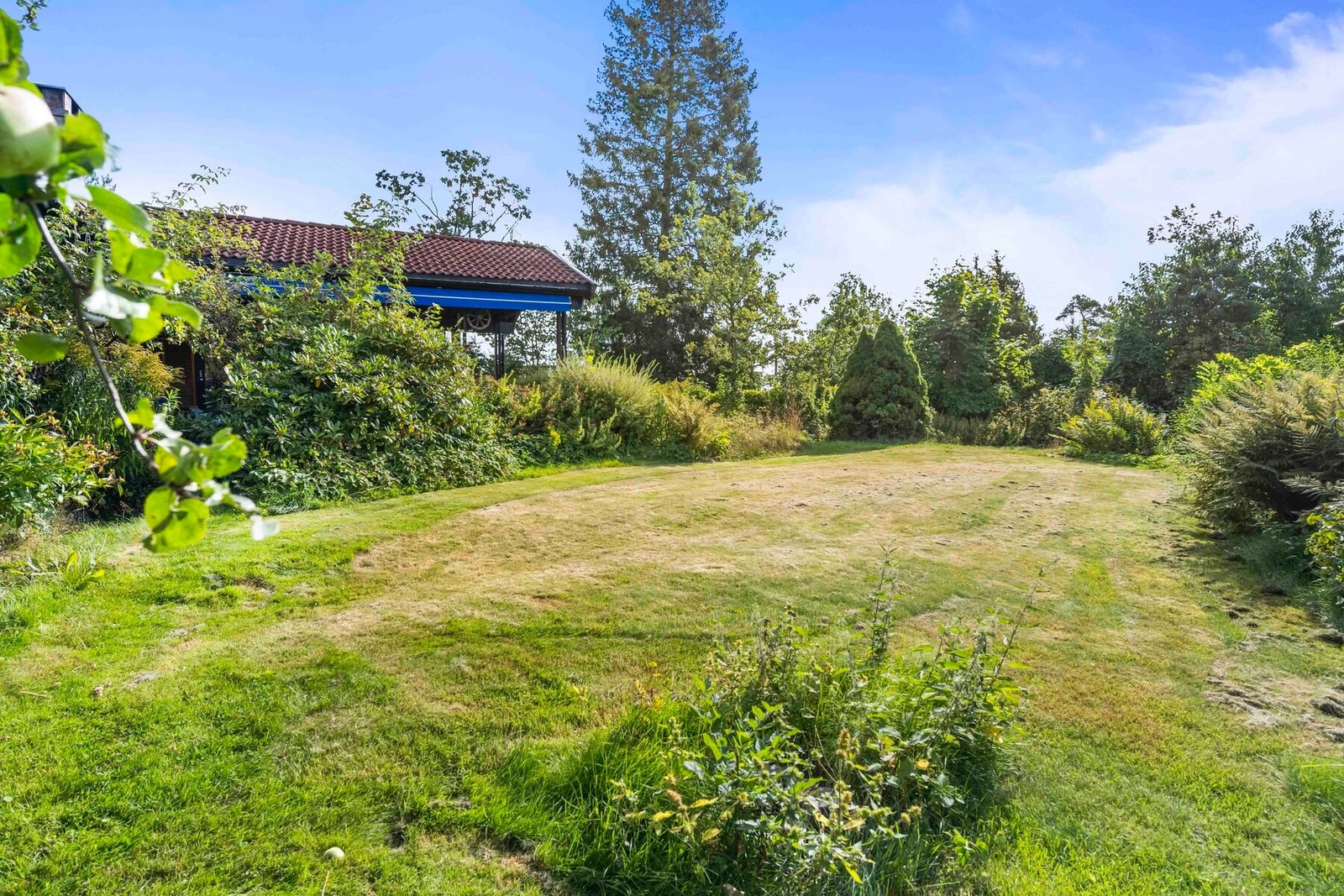 Boligen har en stor og frodig hage. Galleribilde