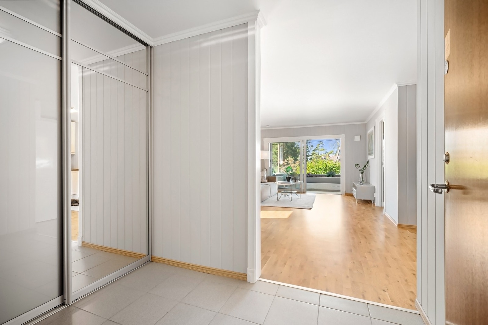 Romslig entré med praktisk skyvedørsgarderobe Galleribilde