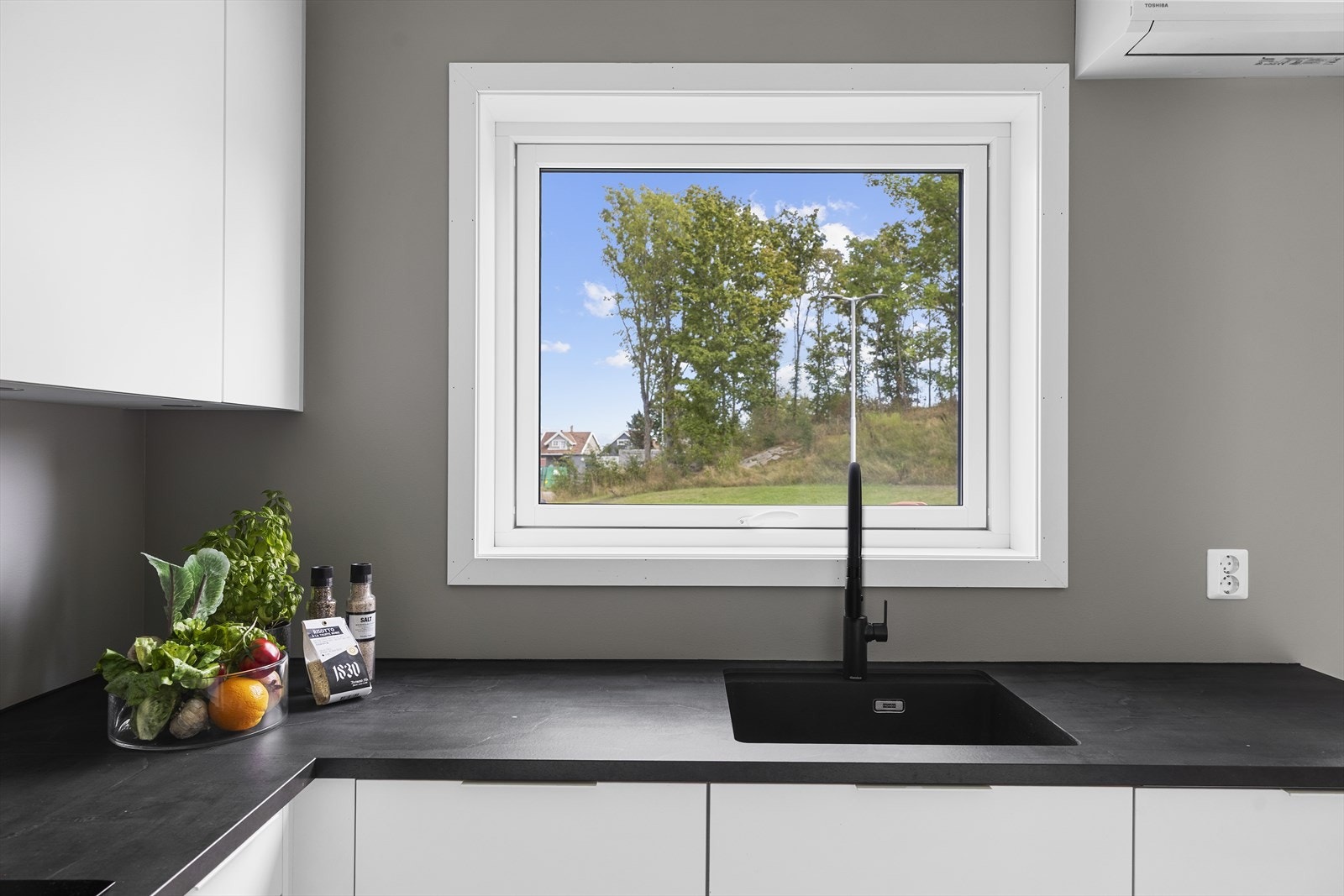 Det er komposit oppvaskkum og mekanisk ventilator over platetopp. Galleribilde