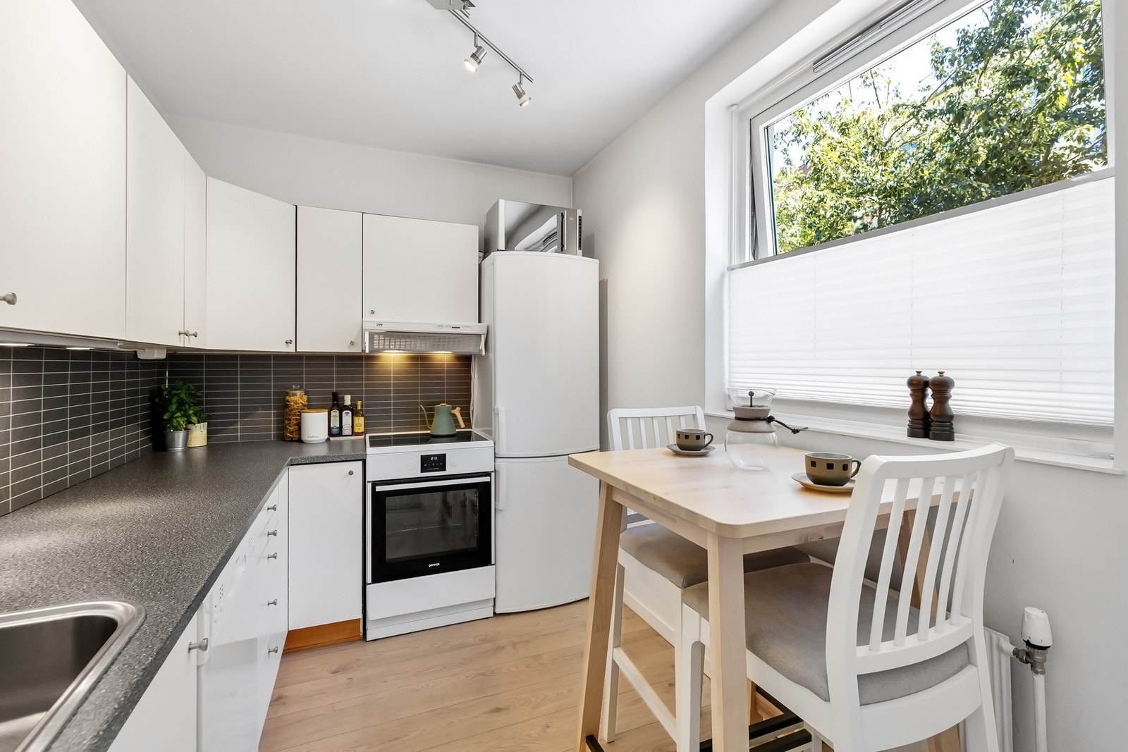 Separat kjøkken med tidløs kjøkkeninnredning med slette fronter og laminat benkeplate. Galleribilde