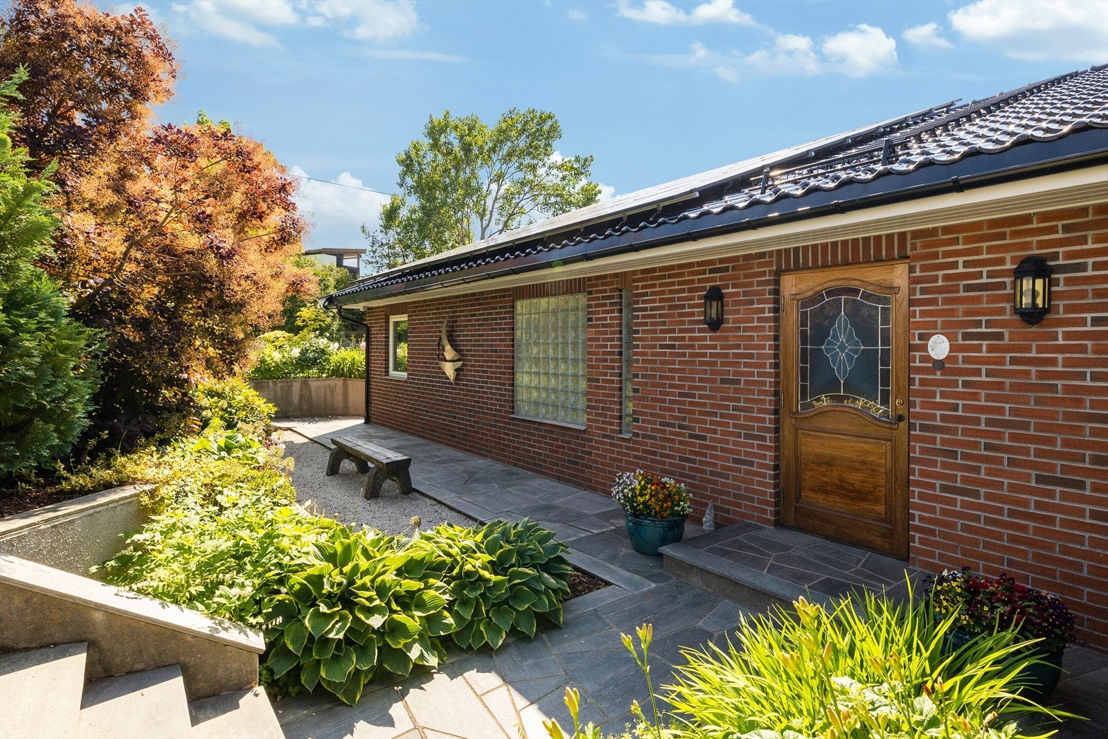 Skiferlagte stier tar deg fra inngangspartiet og rundt til hage og uteplasser. Galleribilde