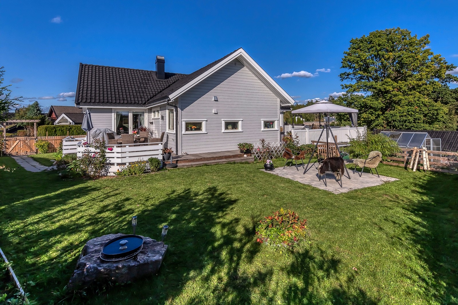 Pent opparbeidet hage med sol "fra morgen til kveld". Galleribilde