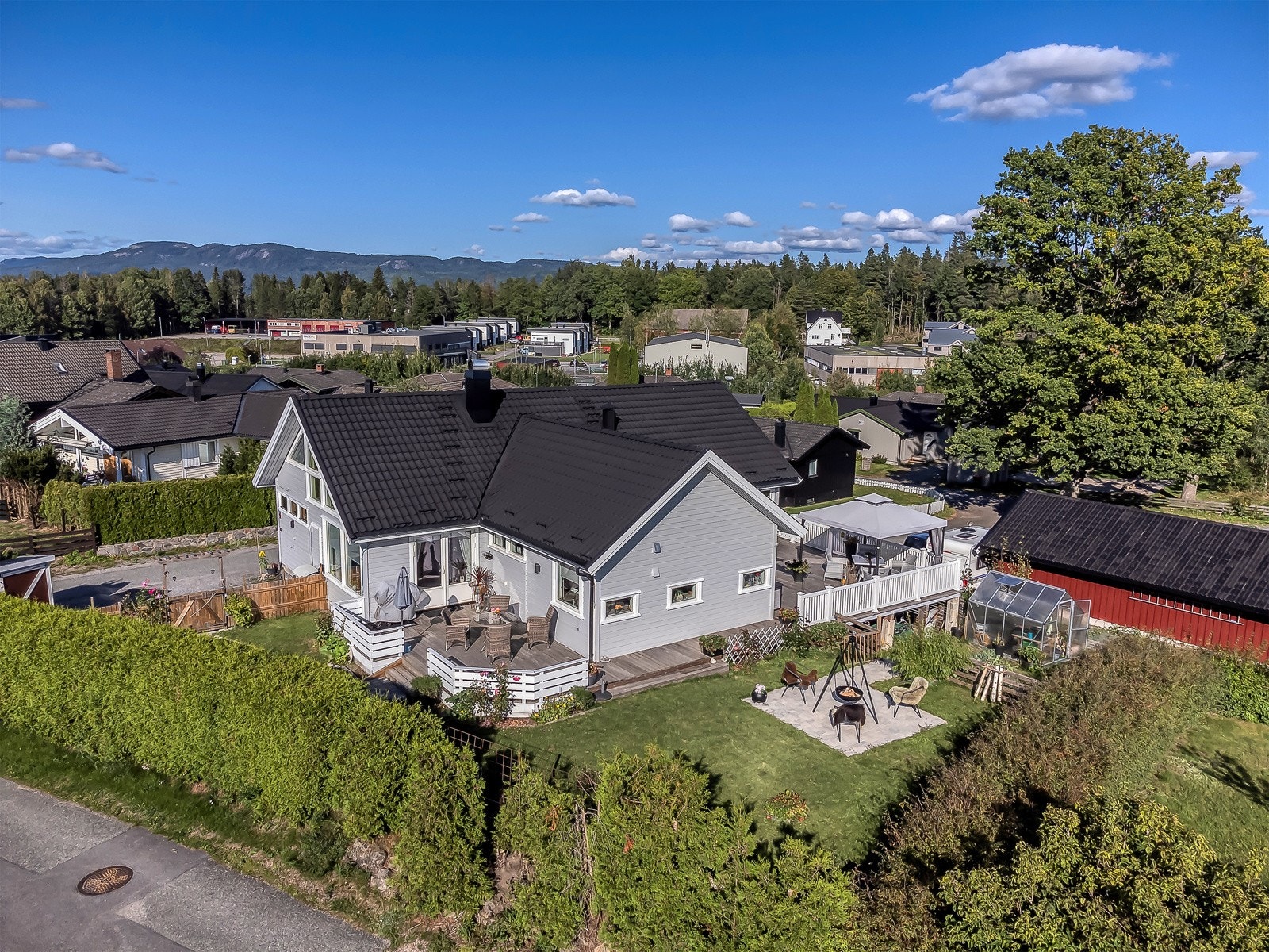 Boligen har en flat opparbeidet tomt med mange uteplasser. Garasjen til boligen ligger i det røde bygget til venstre i bilde. (se nermere beskrivelse på bilde nr 31) Galleribilde