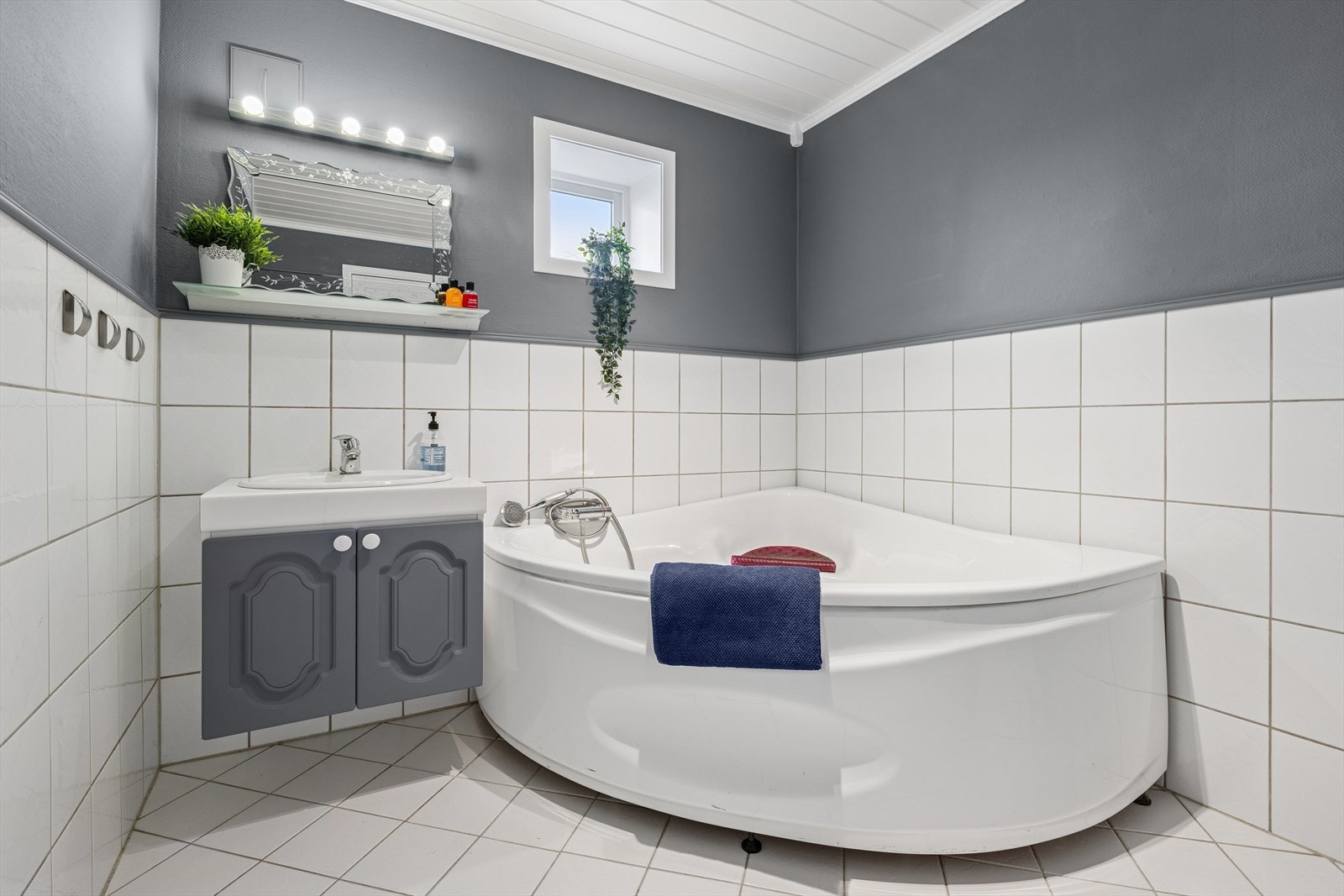 Baderommet i 1. etasje er utstyrt med badekar med hånddusj, Wc på sokkel, servantinnredning og oppbefaringsskap. Galleribilde