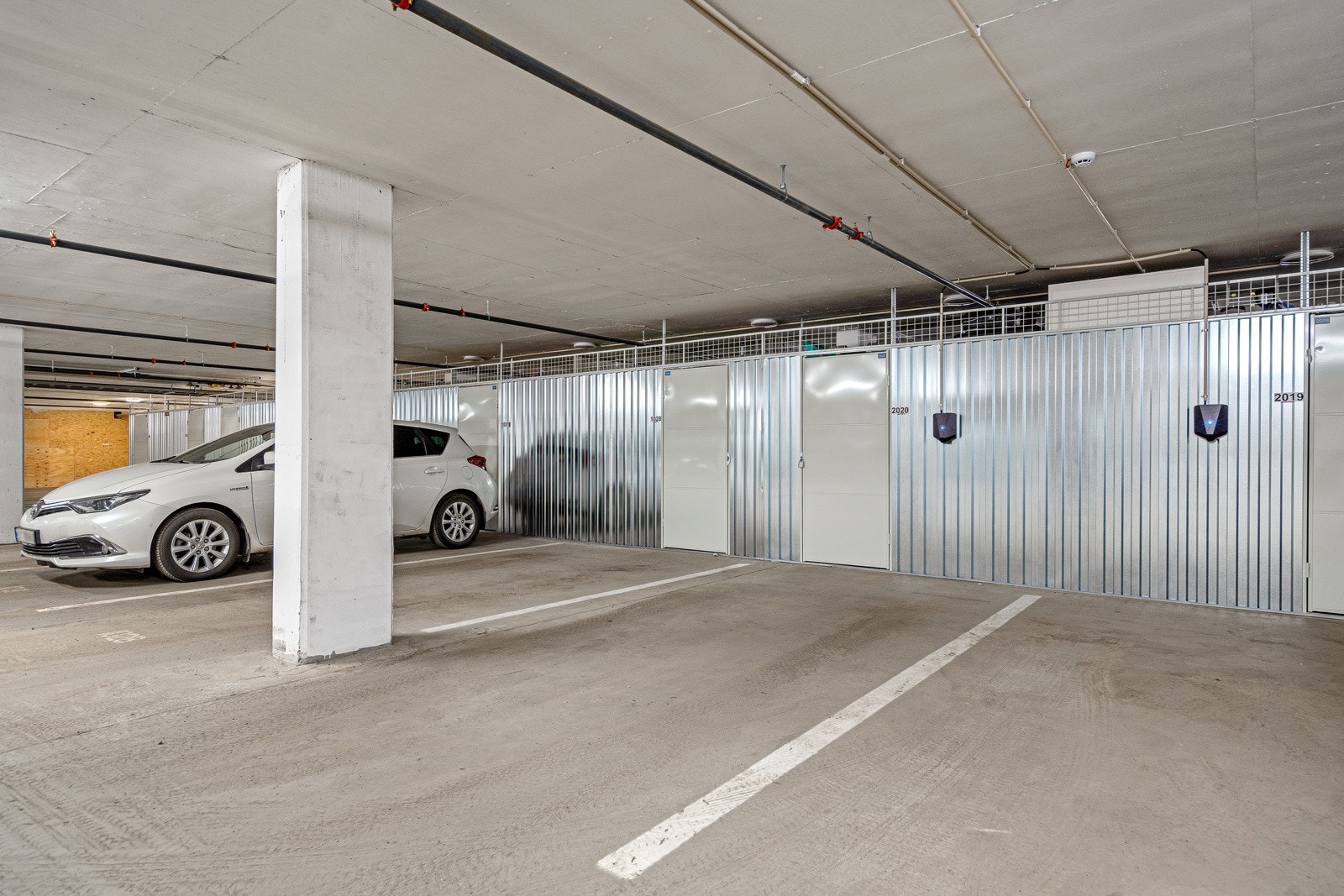 Tilhørende p-plass i byggets garasje, her med egen, lukket bod i bakkant og elbillader Galleribilde