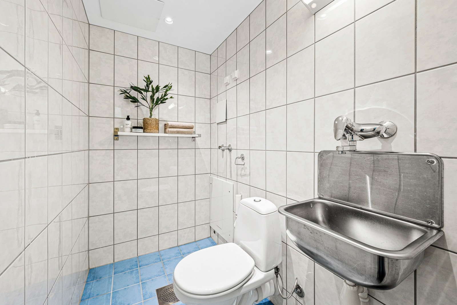 Toalettrommet (ferdigstilt som bad) har flislagt gulv og malte plater på vegger og himling. Opplegg for vaskemaskin. Mulighet for dusjkabinett. Galleribilde