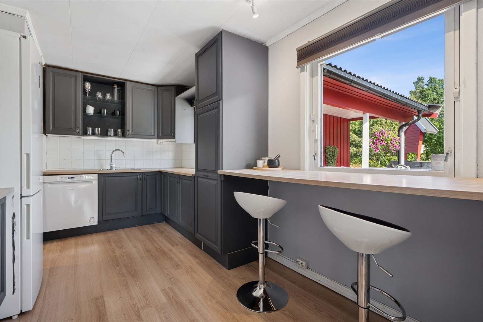 Kjøkkenet har mørk profilert kjøkkeninnredning, benkeplate av laminat, utslagsvask med blandebatteri og opplegg for oppvaskmaskin. Avsatt plass til komfyr, oppvaskmaskin og kjøl-/fryseskap. Galleribilde