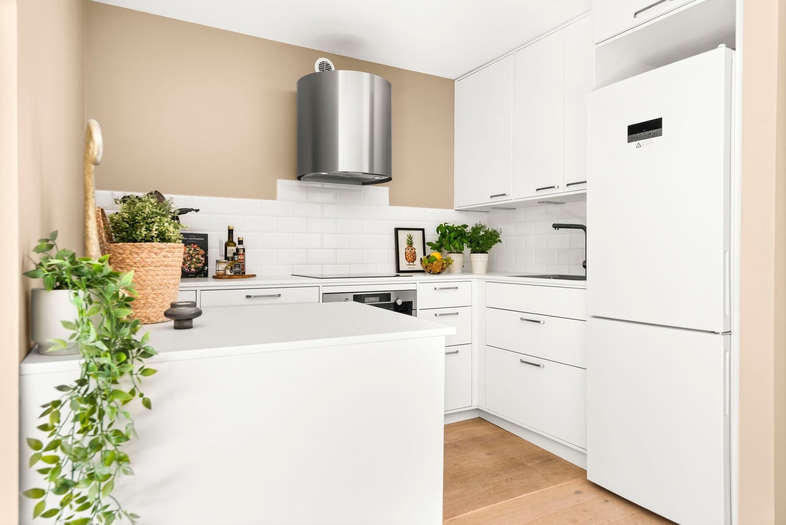 Kjøkkenet kan by på godt med oppbevaringsplass i skuffer og skap. Flotte klassiske avlange blanke fliser over benkeplate. Galleribilde