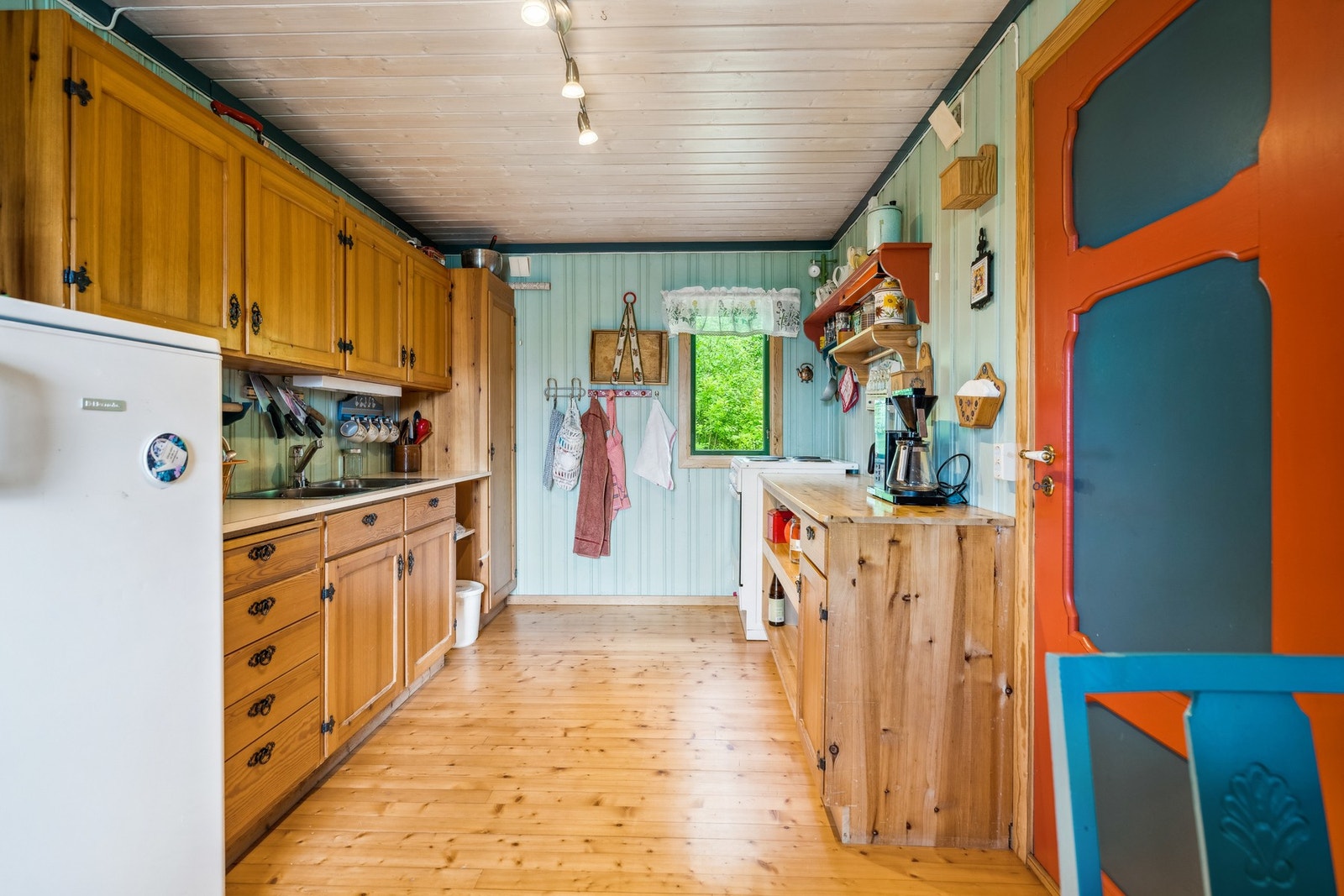 Kjøkkeninnredningen er innredet med skap og skuffer med fronter av heltre furu og benkeplate i laminat Galleribilde