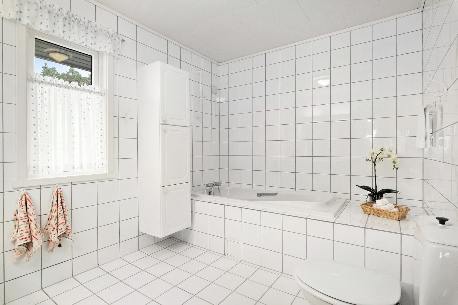 Badet i hovedetasjen er helfliset og har badekar. Galleribilde