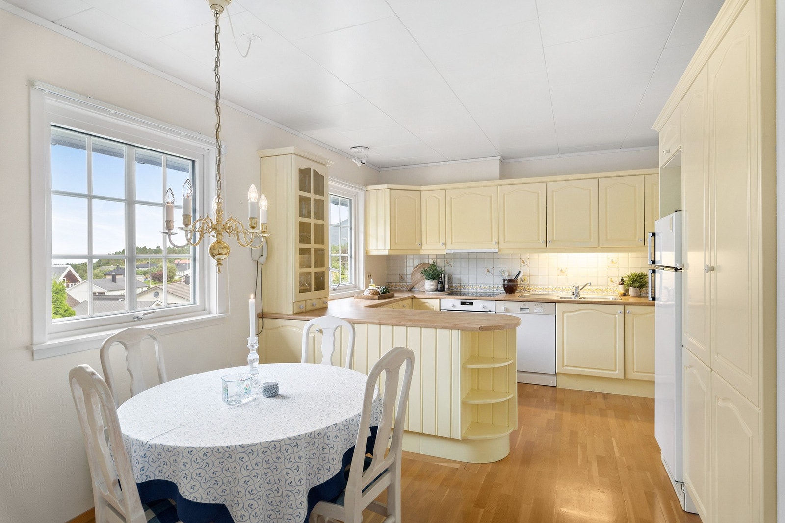 Koselig innredning på kjøkken med hesteskoform i tillegg til innholdsrike høyskap. Galleribilde