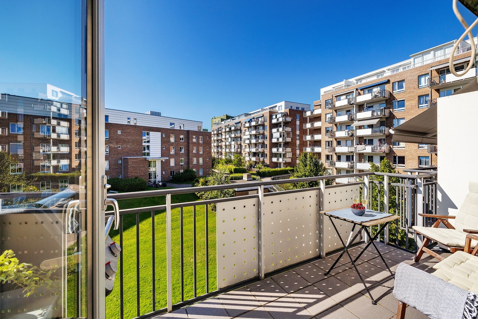 Boligens balkong vender mot vest og gir et hyggelig utsyn mot sameiets pent opparbeidede fellesområder. Galleribilde