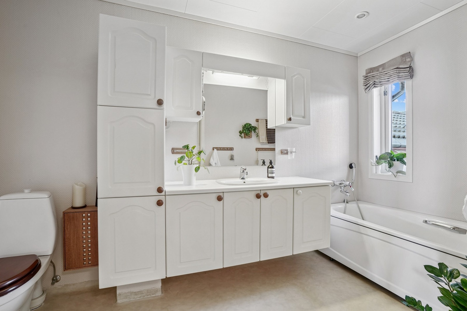 Lyst bad med våtromstapet/belegg og vinylbelegg med elektriske varmekabler. Galleribilde