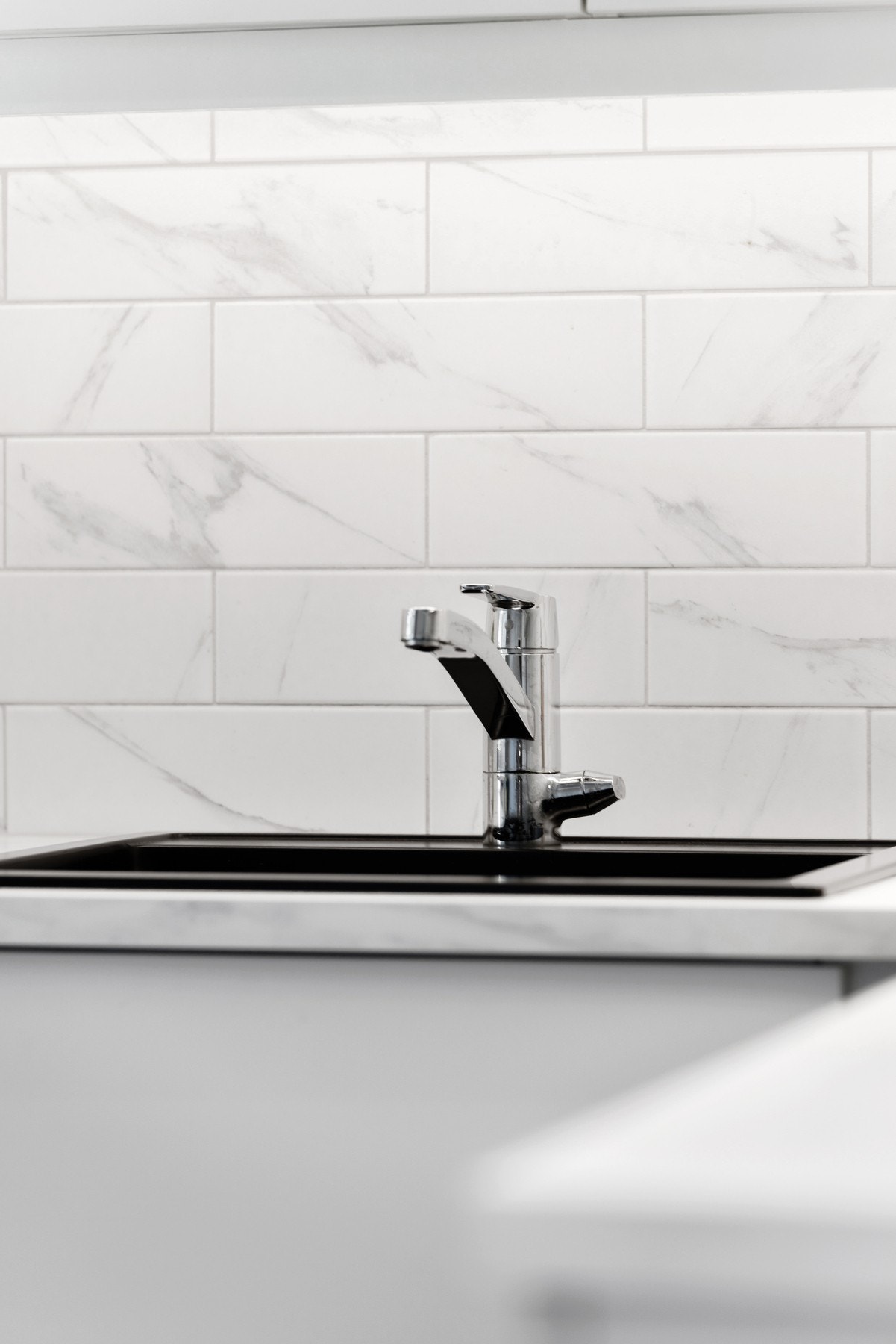 lotte fliser mellom benkeplate og overskap med belysning under. Galleribilde