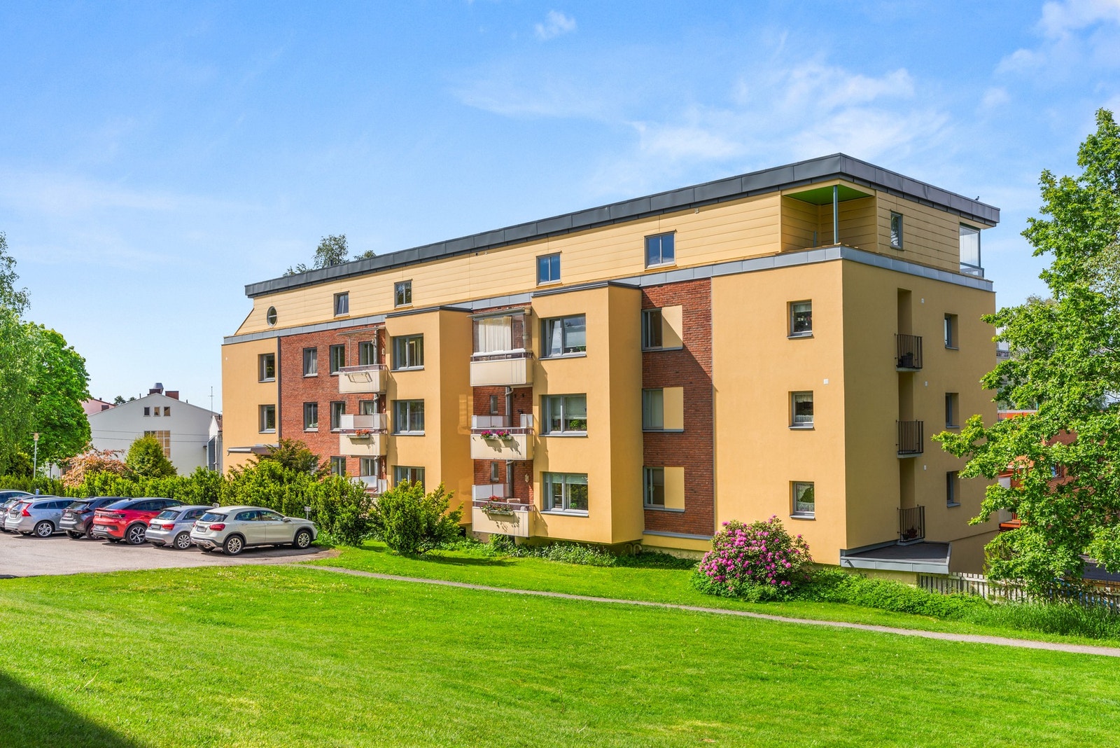 Sameiets tomt er parkmessig opparbeidet og beplantet med gressplener samt busker og trær. Galleribilde