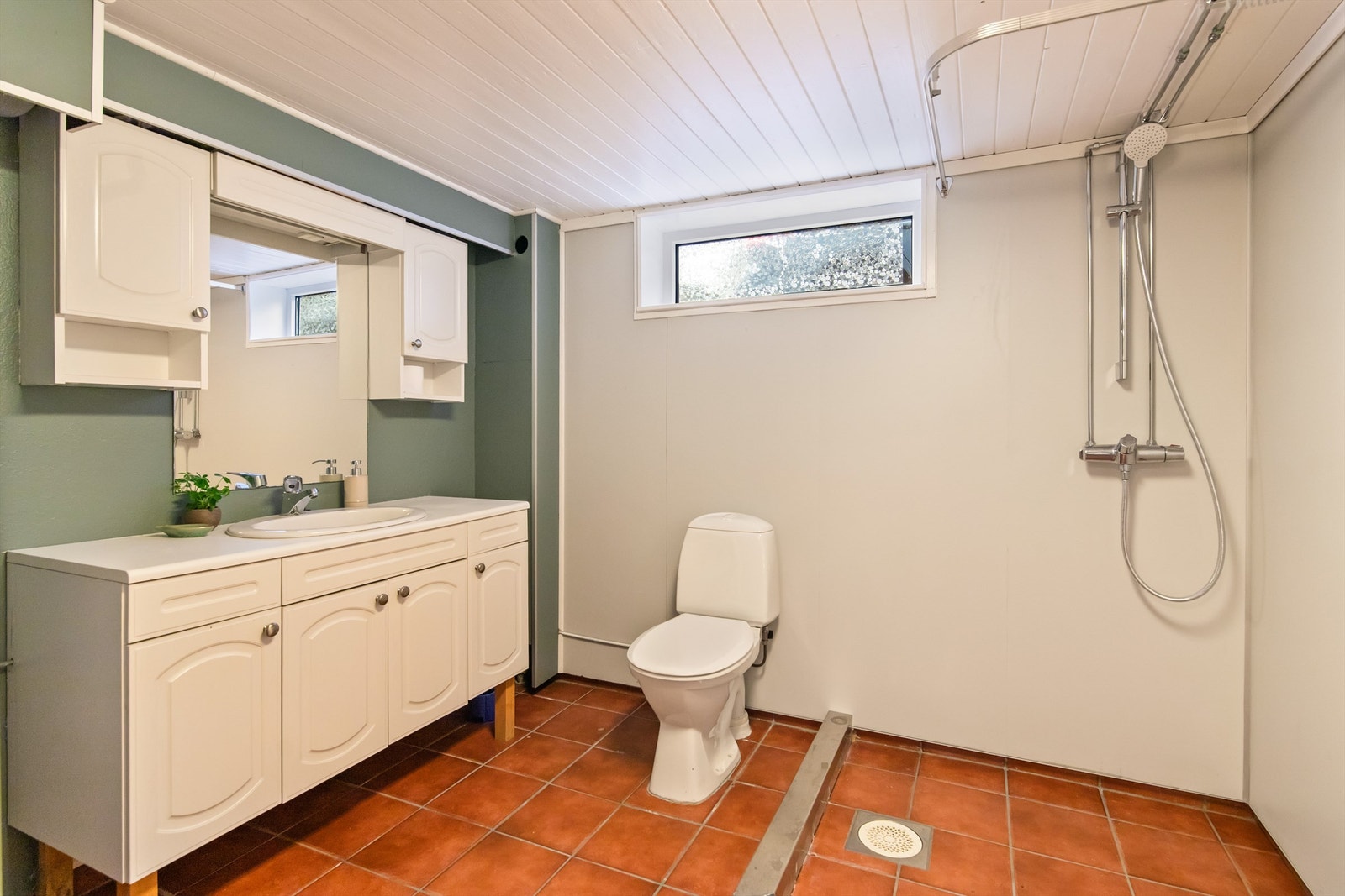 Badet i kjelleretasjen mot øst har fliser på gulvet og veggflater med malte flater og baderomsplater. Galleribilde