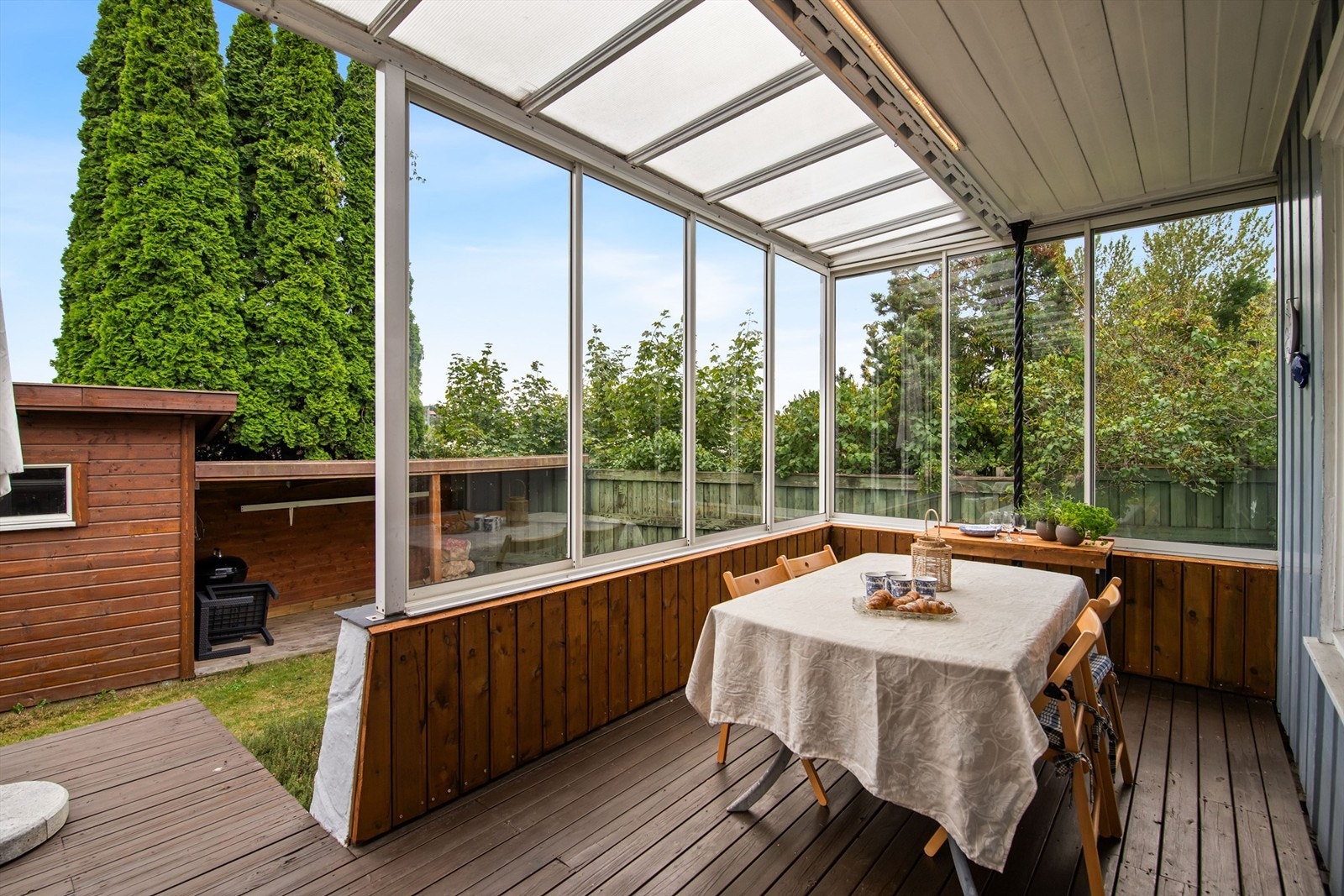 En del av uteplassen er innglasset, slik at du kan sitte lunt og skjermet - perfekt for å nyte lange sommerkvelder, uansett vær og vind. Galleribilde