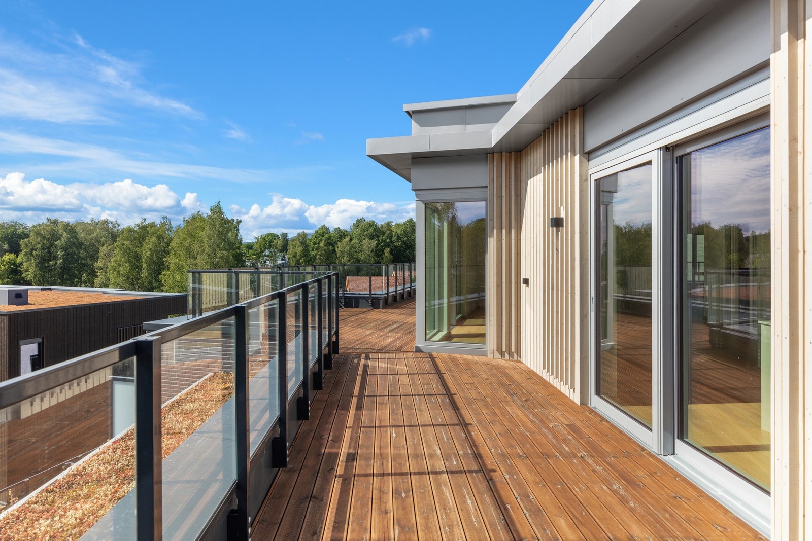 Stor sydvestvendt terrasse med utgang fra stue og kjøkken