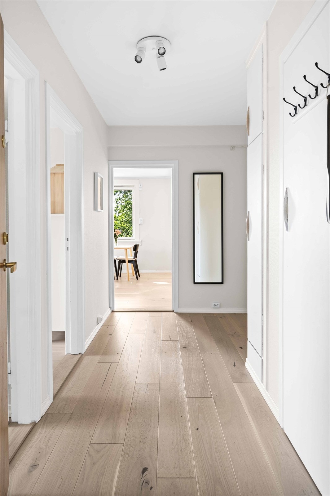 Velkommen inn! Stor og innbydende entré som er med på å gi et godt førsteinntrykk av leiligheten. Her er det rikelig med plass til oppbevaring av yttertøy og sko, i tillegg til bod for ytterlige oppbevaringsplass. Galleribilde