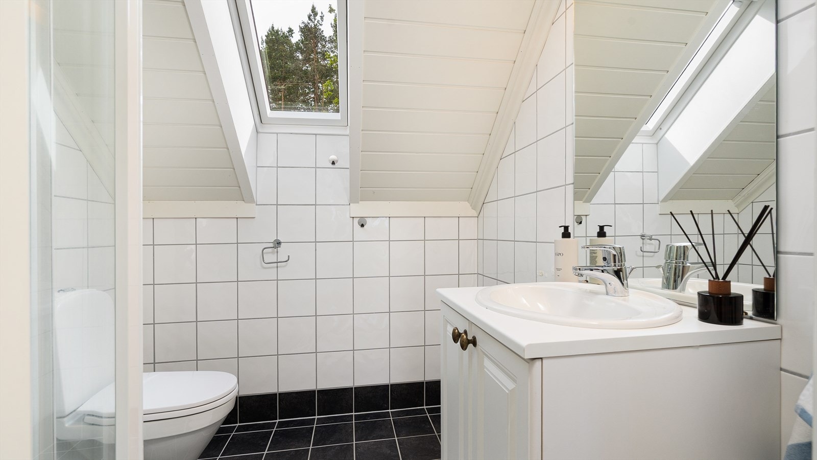 Bad/wc er flislagt med varmekabler i gulv og inneholder wc, servant med skap og dusjhjørne. Galleribilde