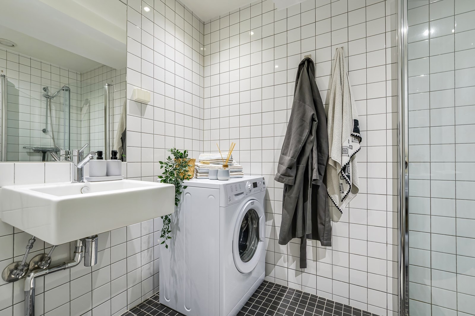 Innredning består av servant, speil, vegghengt toalett og dusjhjørne med glassdører Galleribilde