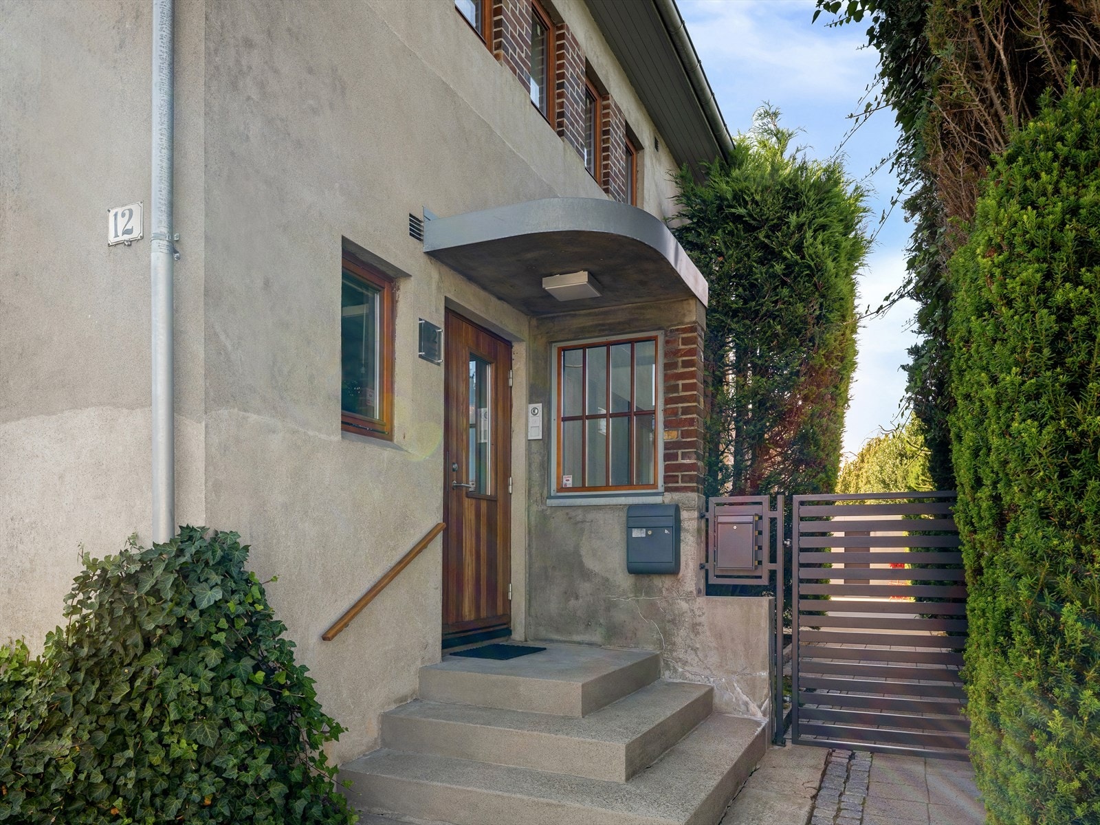 Stilrik murvilla med takoverbygget hovedinngang om du kommer gående. Eller gjester parkerer i gaten. Port privatiserer eiendommen videre. Galleribilde