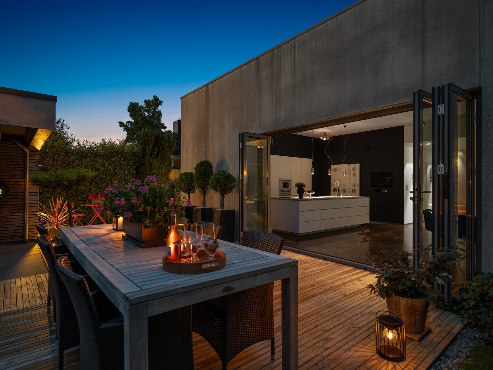 Selve hjertet i huset: Et stort åpent kjøkken og allrom. Store foldedører langs endeveggen åpner opp hele rommet og gjør at du glir sømløst mellom inne og ute. I dette hjemmet er hagen og de grønne lungene essensen i atmosfæren. Galleribilde