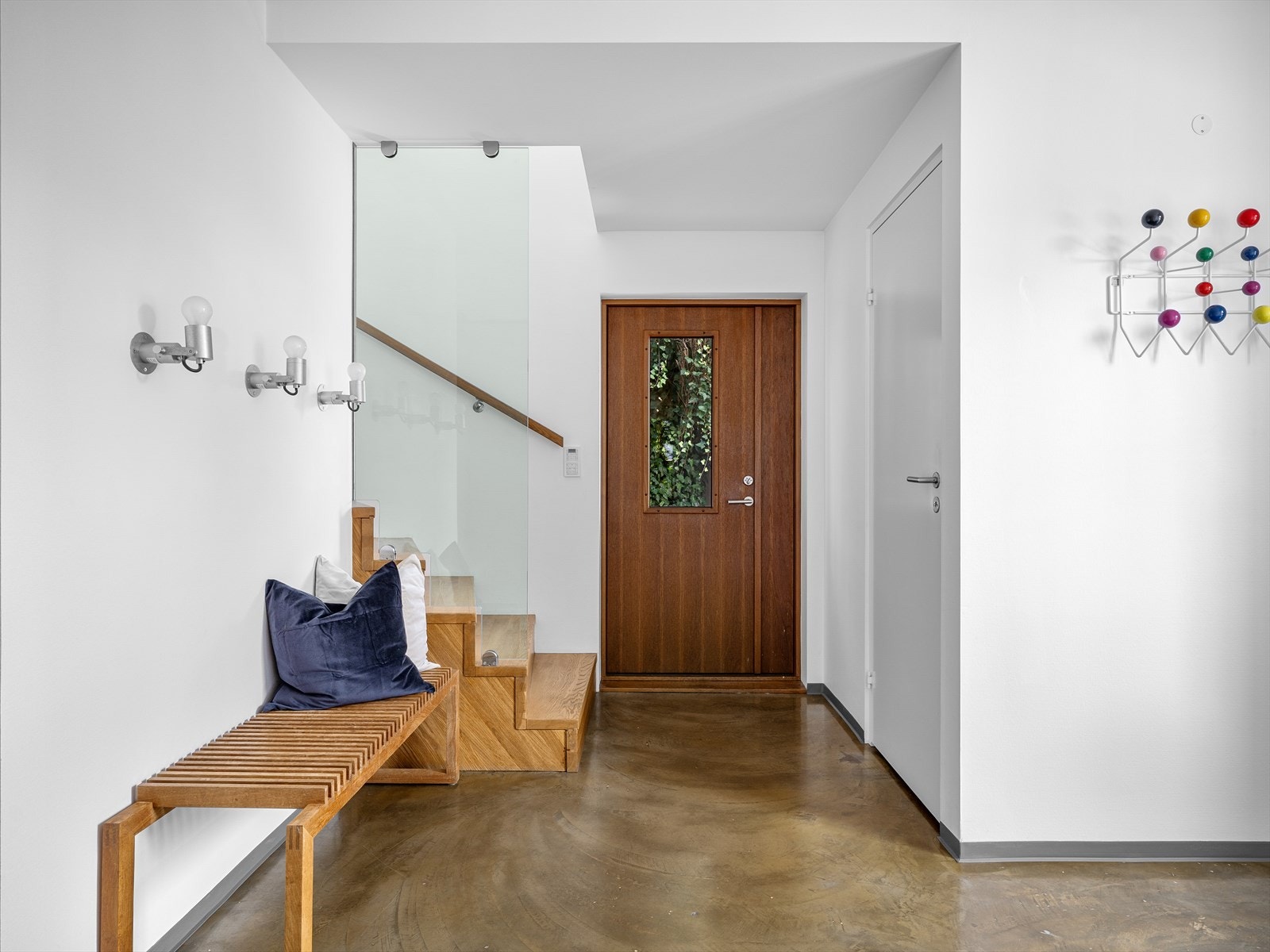 Heltre eiketrapp med glassrekkverk i pen kontrast. Her kan du ha både påkledningsbenk og garderobe. Gjennomtenkt designbelysning. Galleribilde