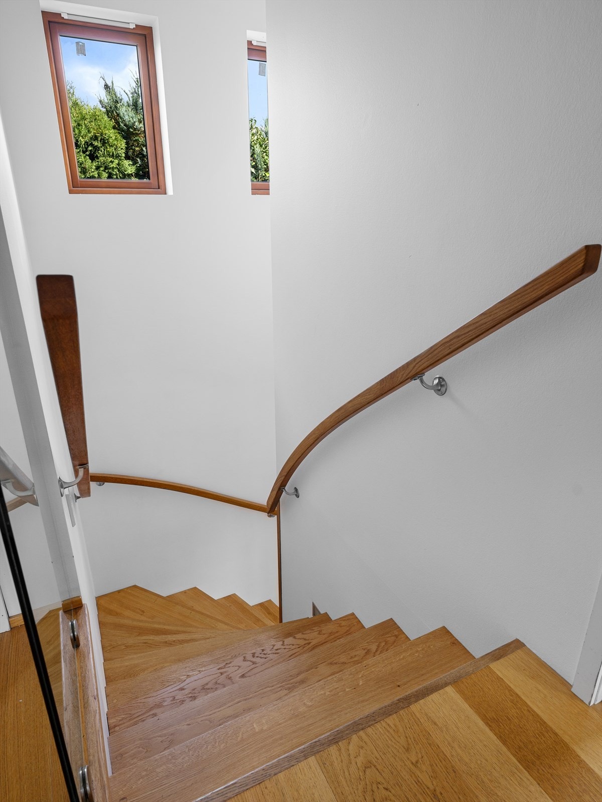 Heltre eiketrapp opp til andre med flere vinduer for naturlig lys i trappegang. Galleribilde