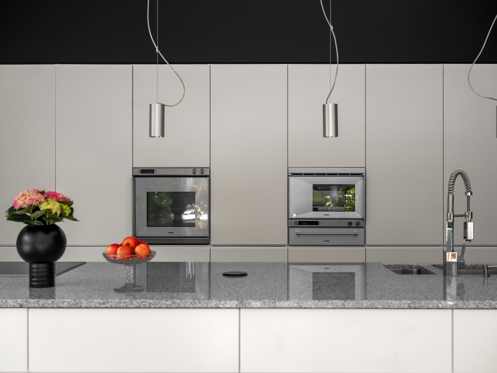 Granitt i ett, helt stykke. Underlimt vask. Stikkontakt i benk for kjøkkenmaskiner. Gaggenau hvitevarer. Her koser kokken seg. Galleribilde