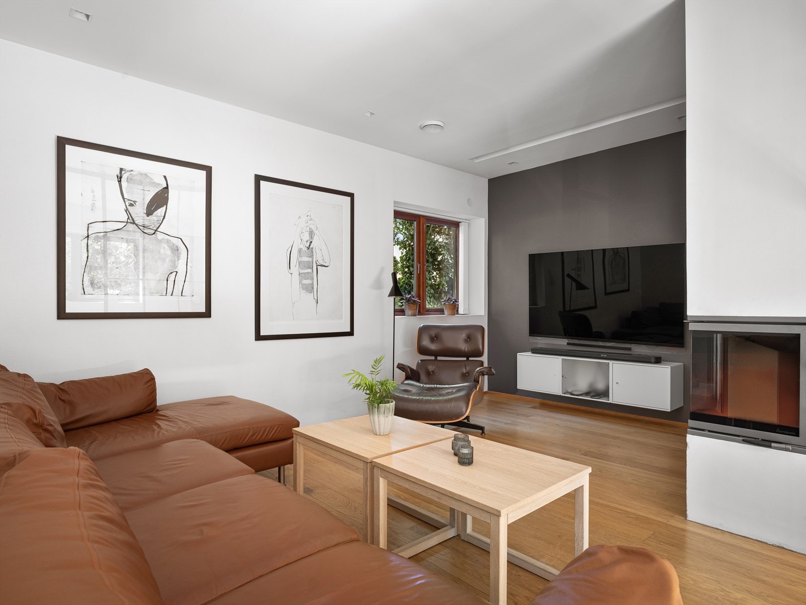 En intim og herlig tv/peisestue med smart hylleløsning. Rikelig med naturlig lys, og fint bortgjemt tv-krok. Galleribilde