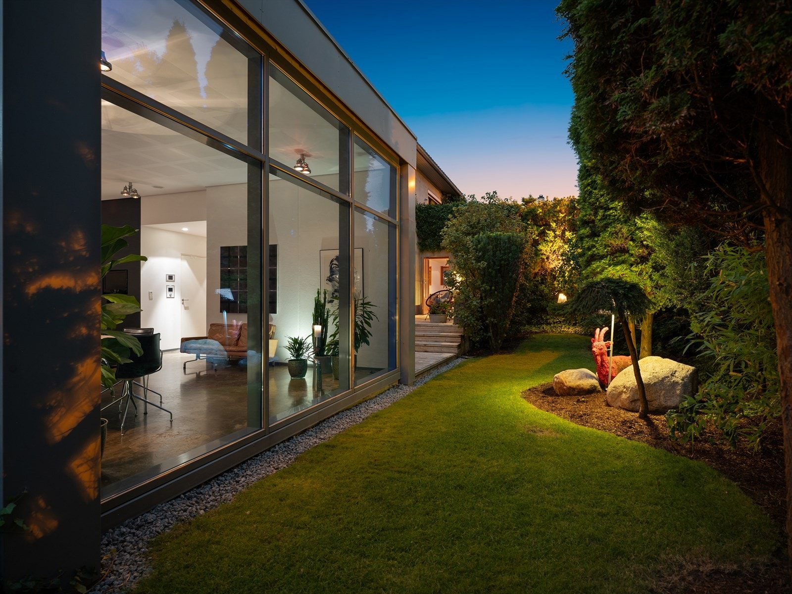 Langs huset har du en solrik og lun hage med flere soner og platåer, fullstendig skjermet for innsyn. I dette hjemmet er hagen og de grønne lungene essensen i atmosfæren. Galleribilde