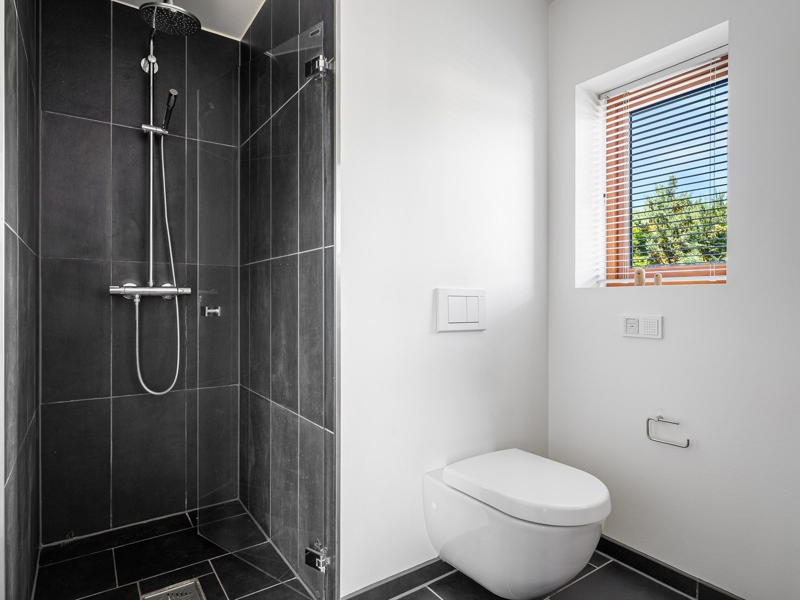 Eget innhukk for dusjen med vannfallsdusj og håndholdt. Naturlig lys via vindu gir herlig atmosfære. Galleribilde