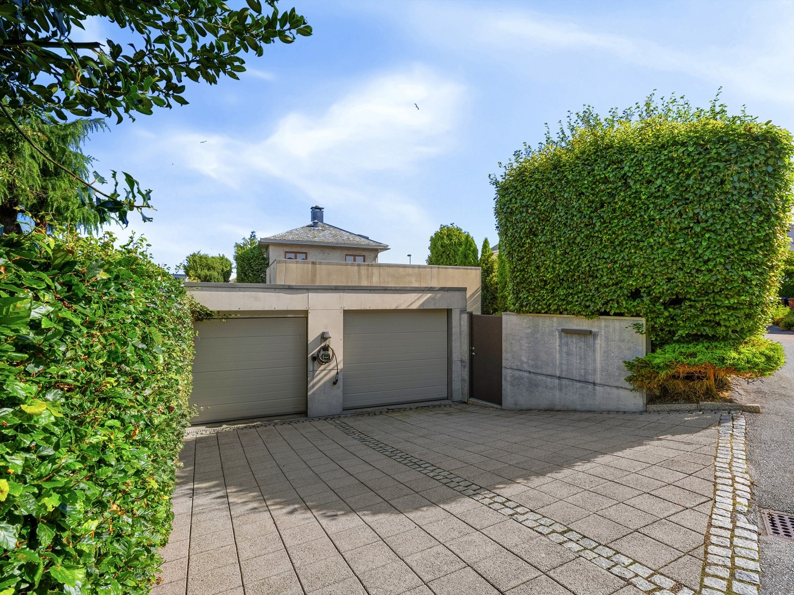 Dobbel garasje/carport med elbil lader både utfor og inni. Varmekabler i innkjørsel. Plass til to biler til i gårdsrom hvor du har fine brosteinsdetaljer rundt hellene. Gateparkering på motsatt ved hovedinngang og port. Galleribilde